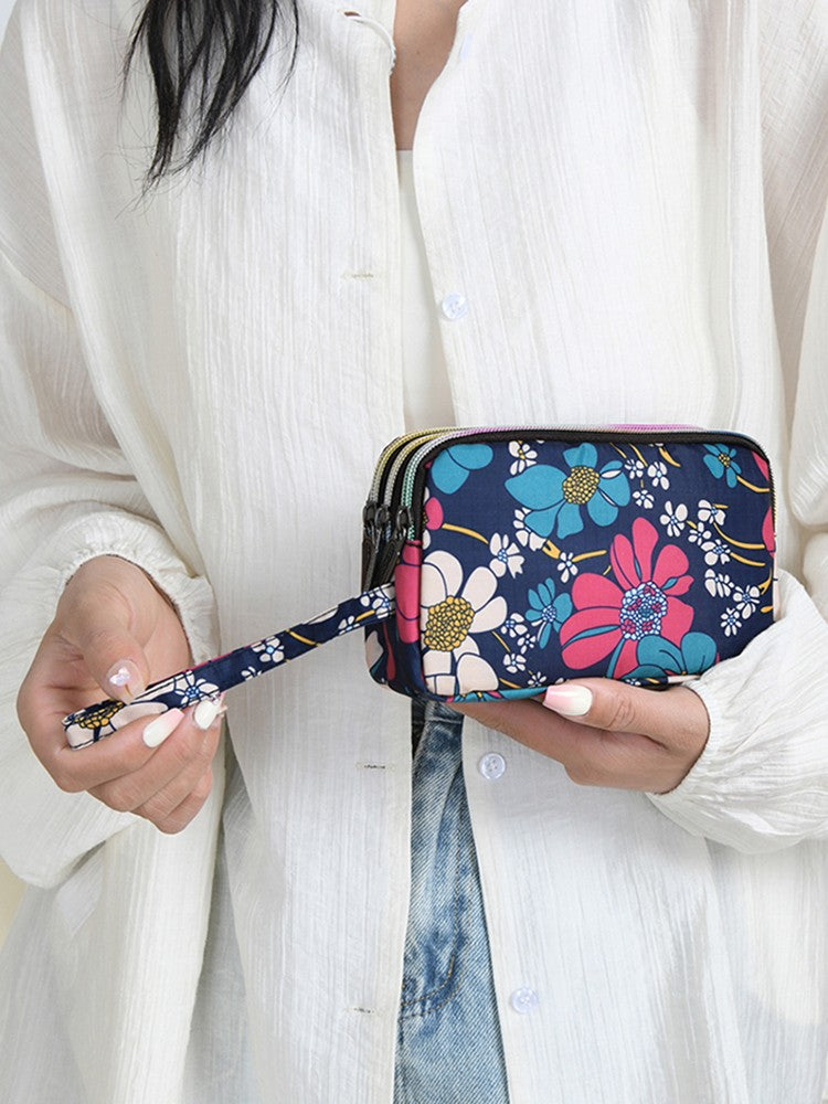 The fashionable lady's clutch and mobile phone bag are rich in floral patterns and elements, and the fabric is soft