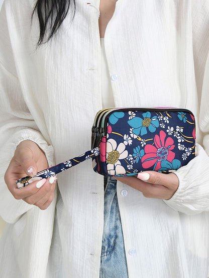 The fashionable lady's clutch and mobile phone bag are rich in floral patterns and elements, and the fabric is soft