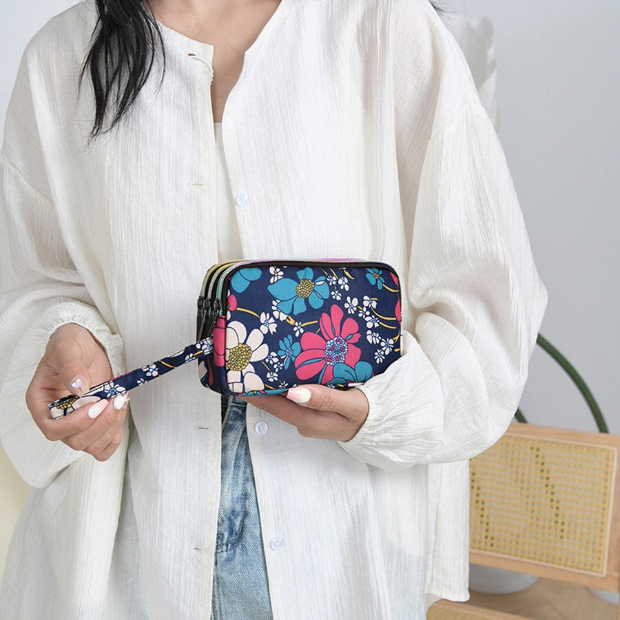 The fashionable lady's clutch and mobile phone bag are rich in floral patterns and elements, and the fabric is soft