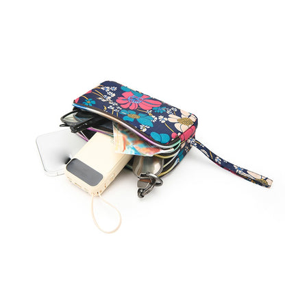 The fashionable lady's clutch and mobile phone bag are rich in floral patterns and elements, and the fabric is soft